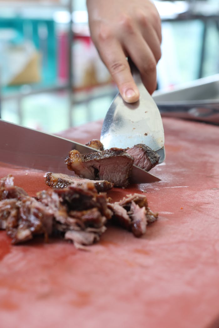 Chef expertly slices juicy, grilled meat—perfect for delicious meals.